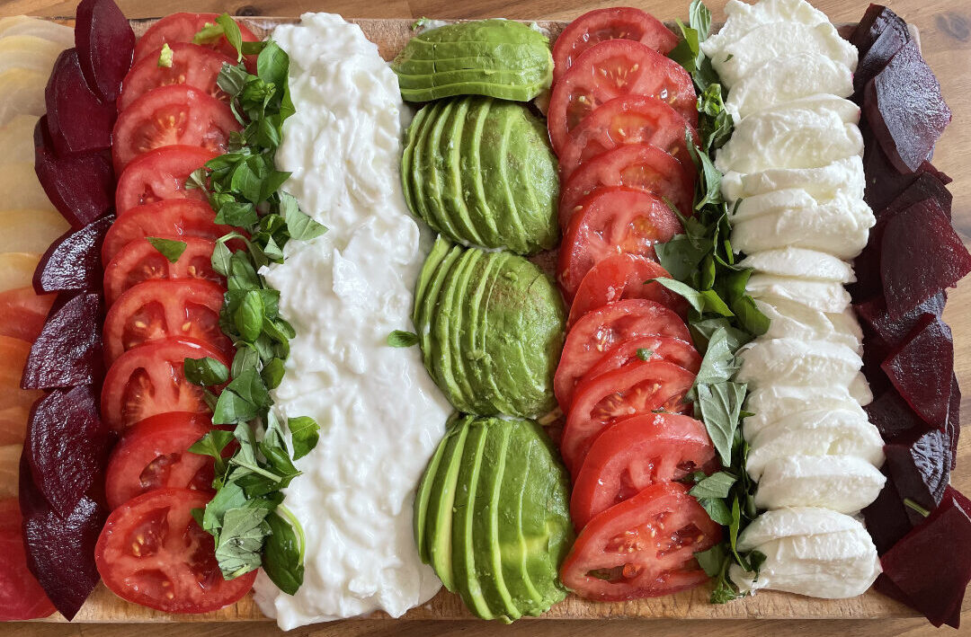 platter with rows of tomatoes, avocado, mozzarella and coleslaw